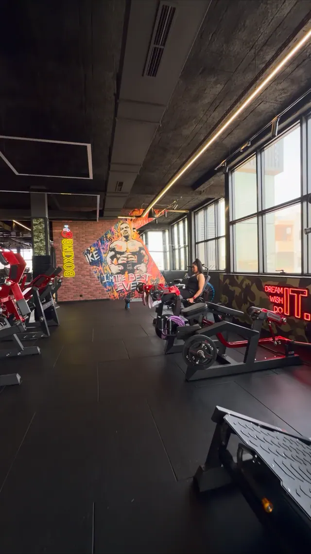 Espace musculation, machines et fresque sportive dans la salle